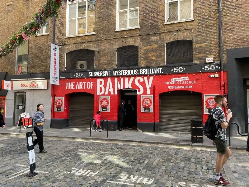 Entrance to a London exhibition with posters across the facade