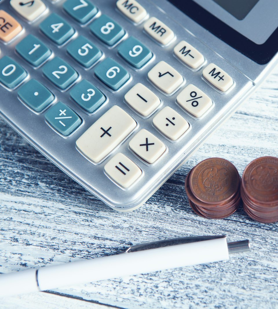 A calculator and coins on a table