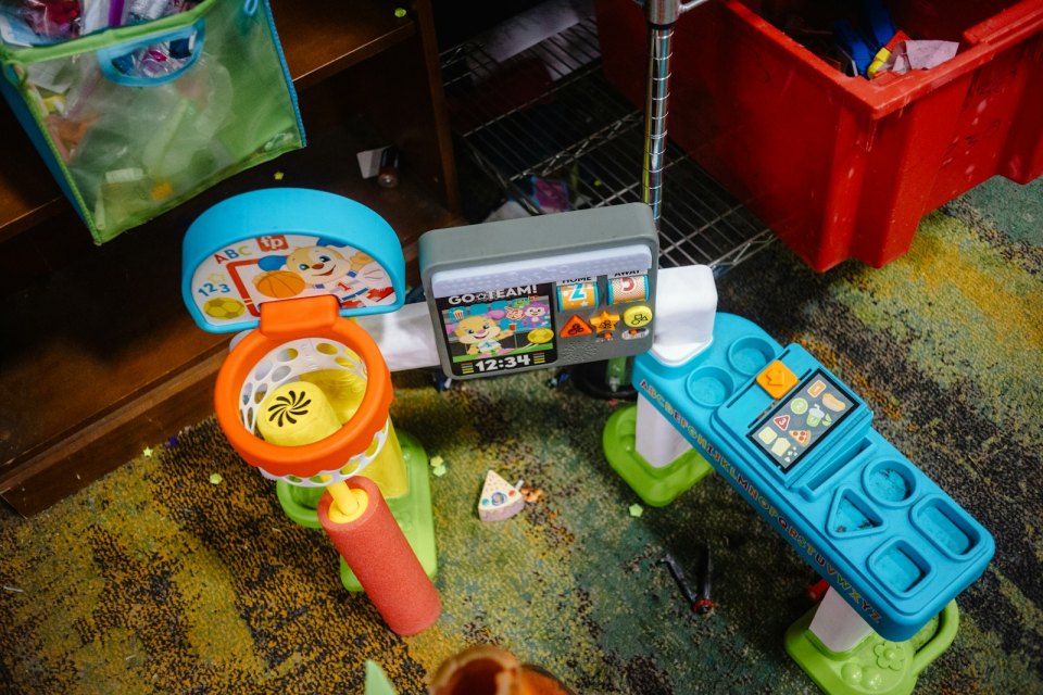 Детские игрушки на полу игровой комнаты