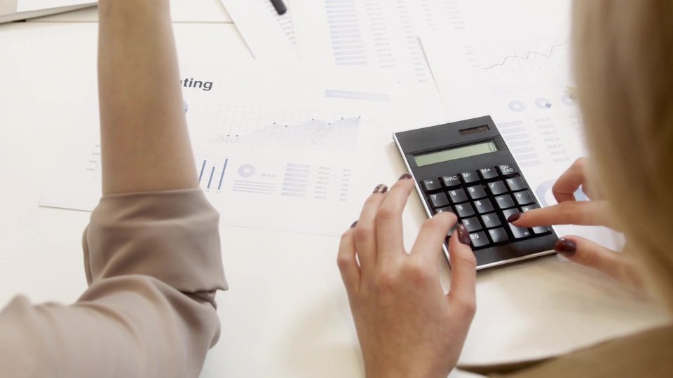 An employee calculates payments at a desk