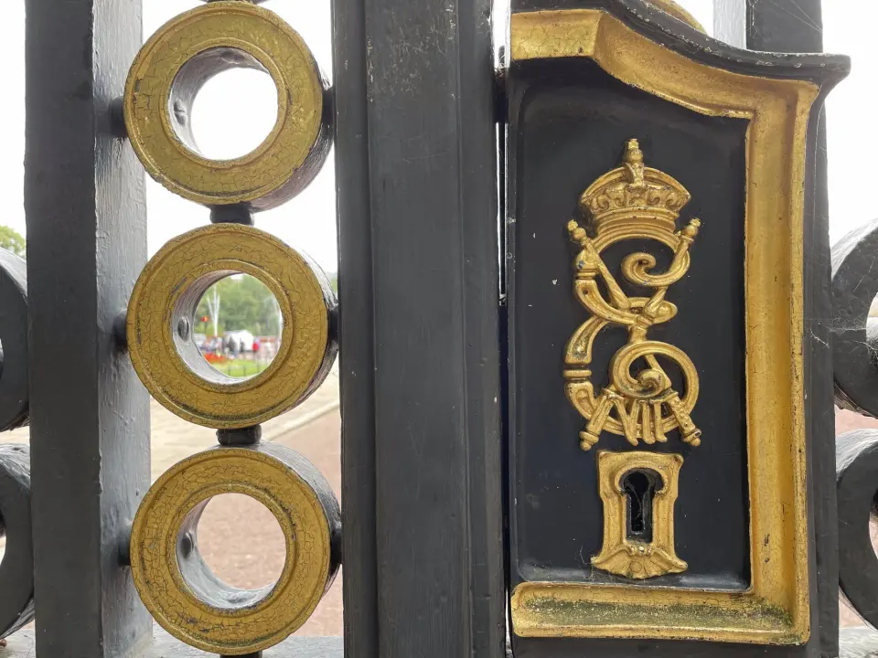Close-up of the Canada Gate by Green Park: a gilded royal cypher and a keyhole on black ironwork