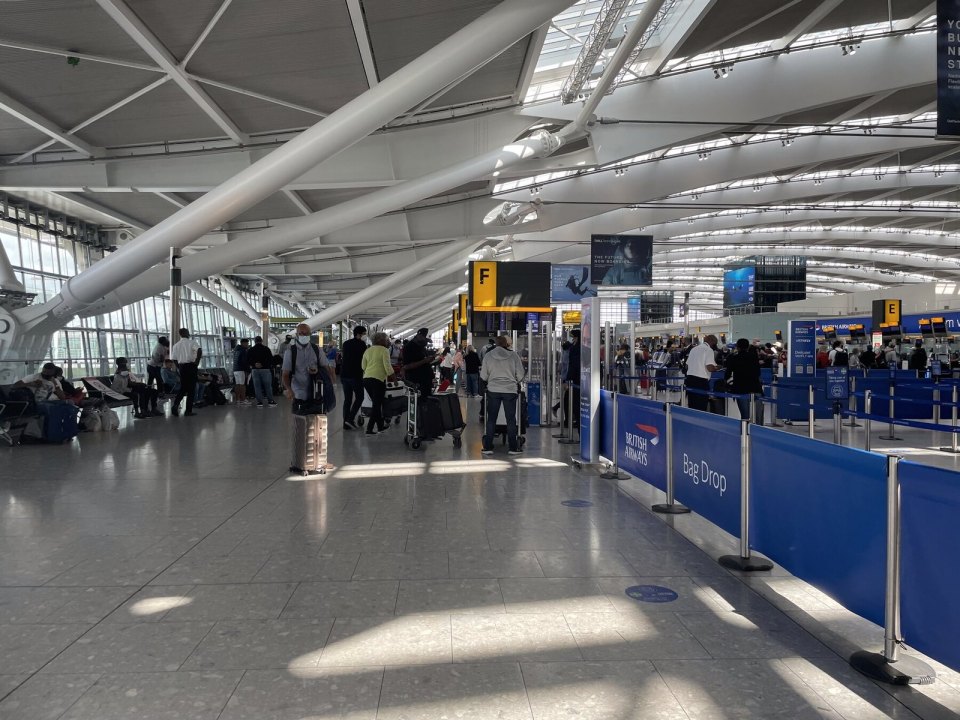 Departures hall at Heathrow Terminal 5, check-in desks and passengers with luggage