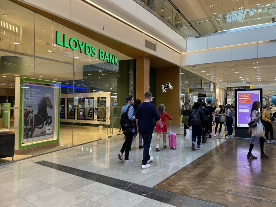 A Lloyds Bank branch inside a shopping centre with people walking past