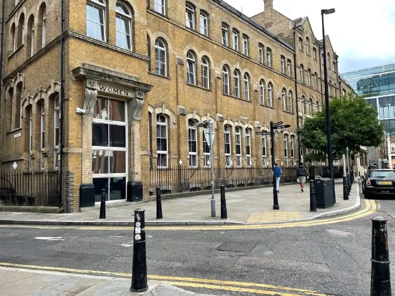 A London brick street with a fingerpost at the corner