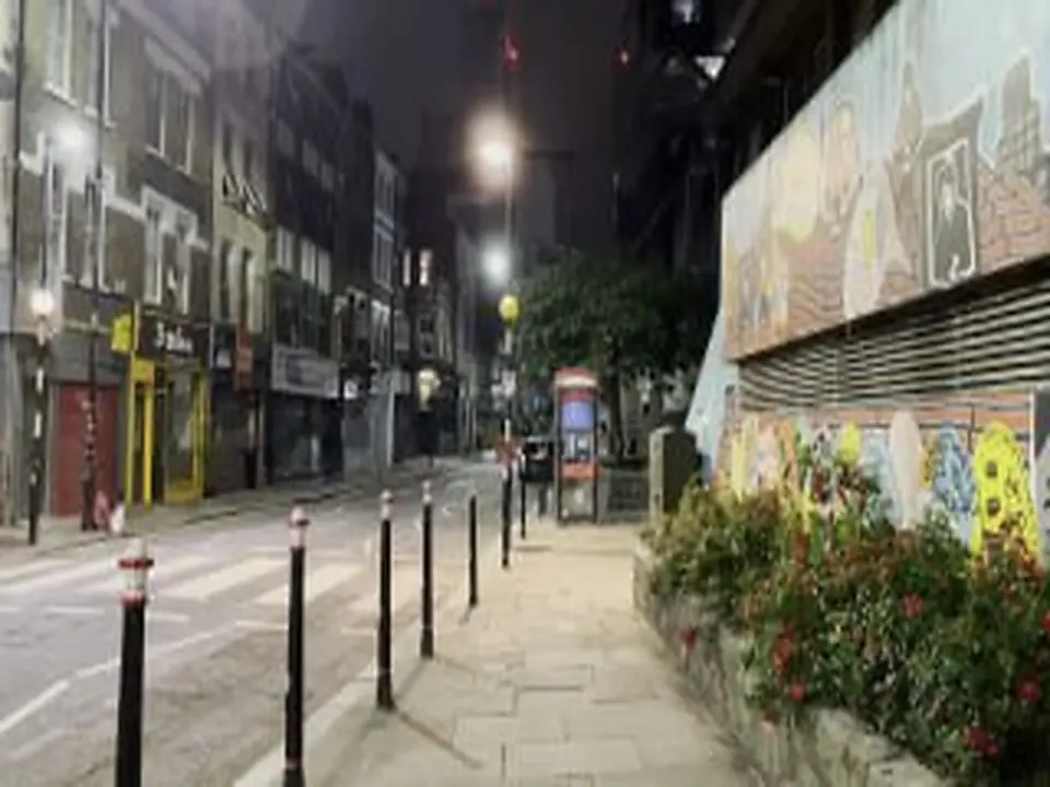 A London street in the evening, streetlights and a painted wall
