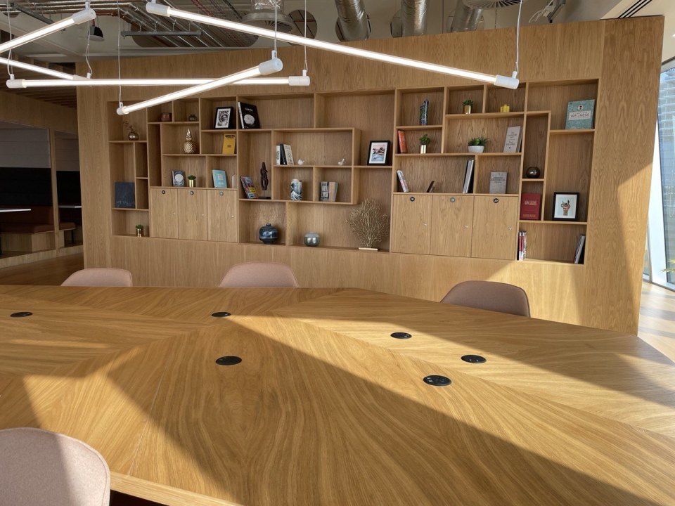 An empty meeting room with a long wooden table in a London office