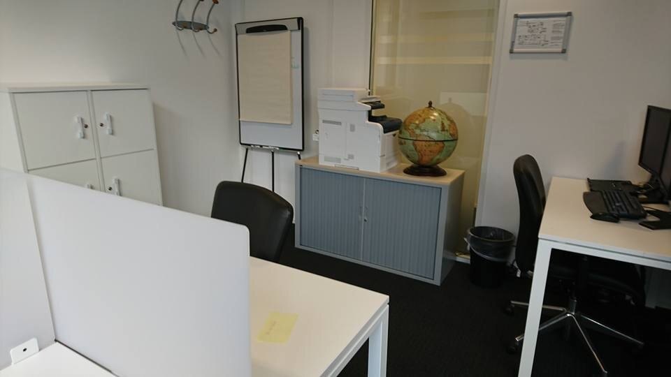 An empty London office room with desks and a flipchart