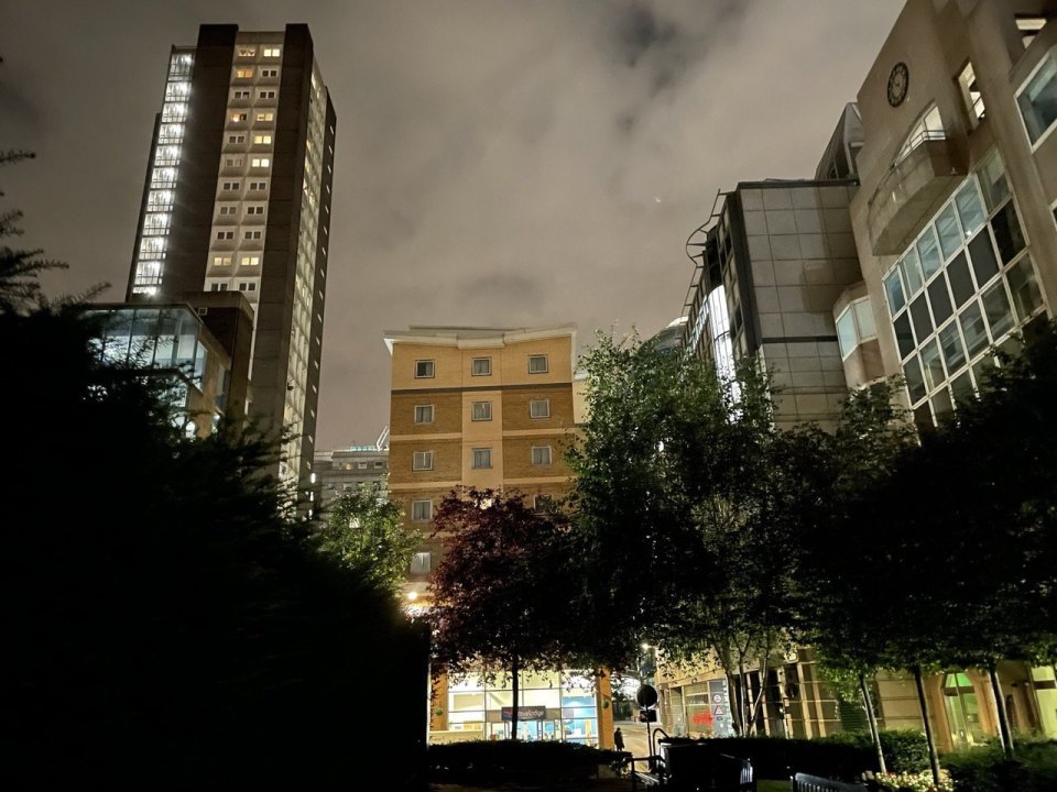 London residential blocks in the evening: lit windows of a tower and a lower building