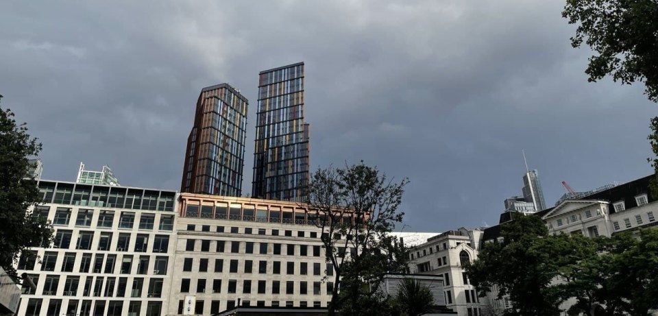 Two modern residential towers with balconies above central London blocks