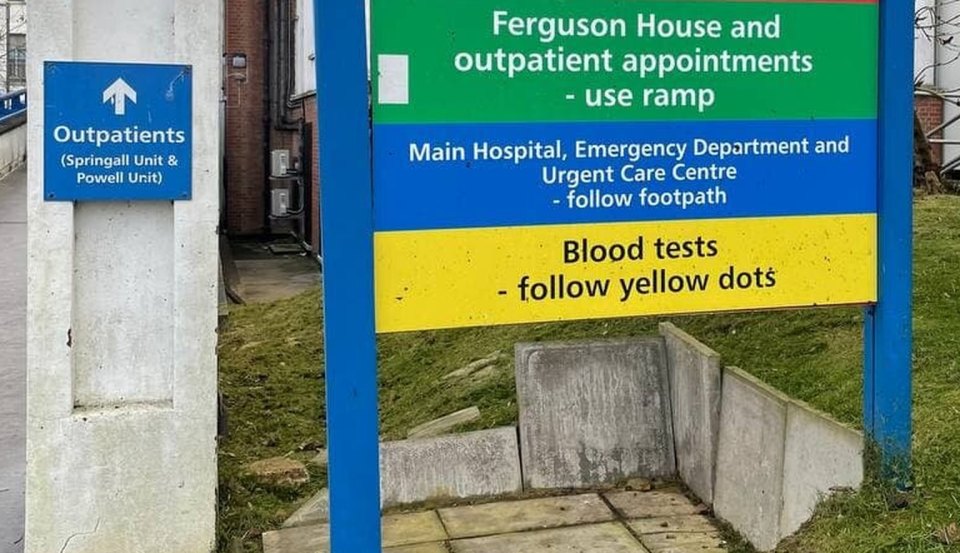 An NHS hospital signboard: outpatients and blood tests
