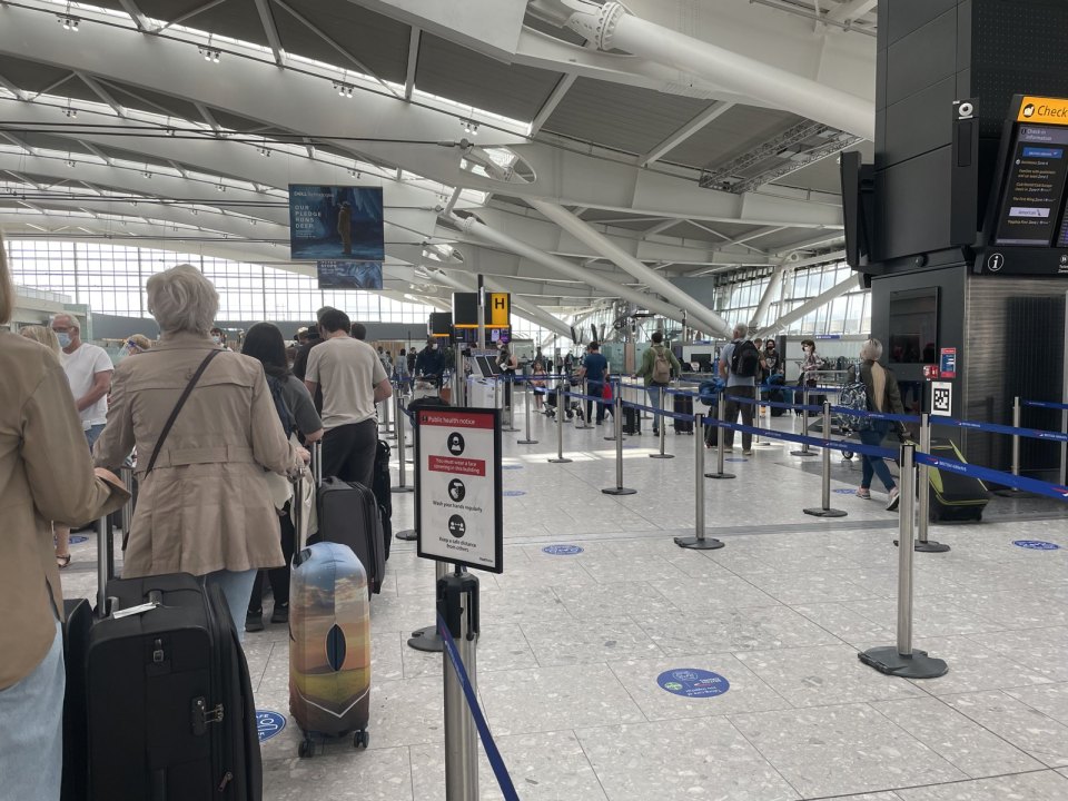 Heathrow check-in hall, passengers queuing with suitcases