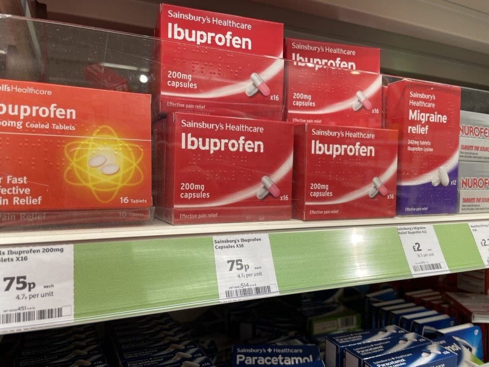 A shelf of over-the-counter painkillers in a British pharmacy