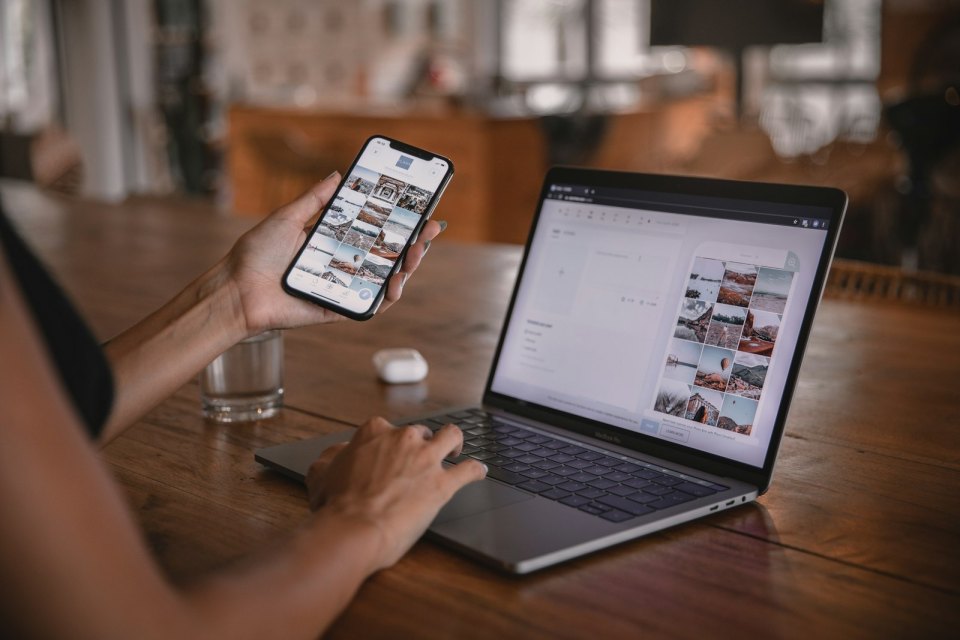 A person using a phone and a laptop