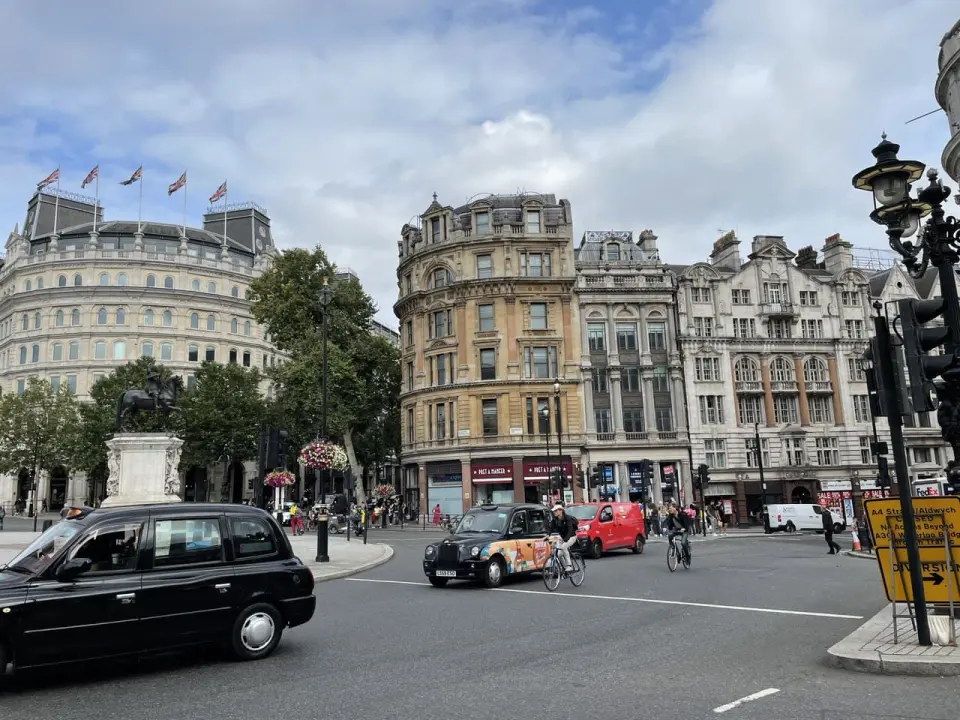 A Victorian London street with a black cab