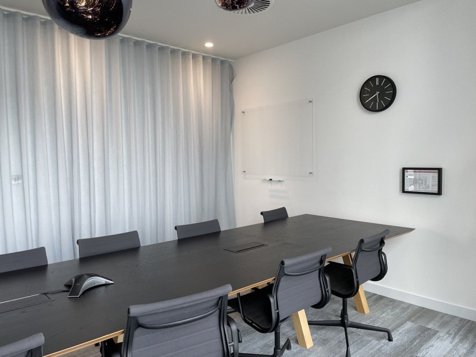 An empty meeting room in a London office: long table, chairs and a wall clock
