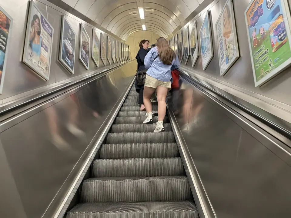 Эскалатор в лондонском метро, пассажиры поднимаются наверх