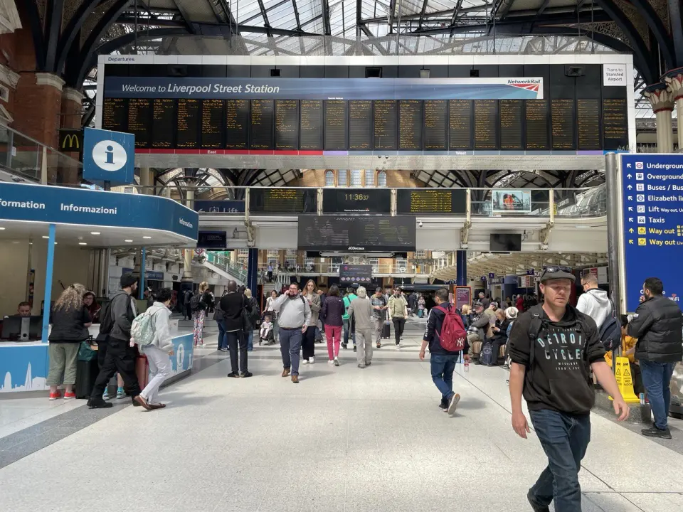 Liverpool Street station concourse in London, people watching the departure boards