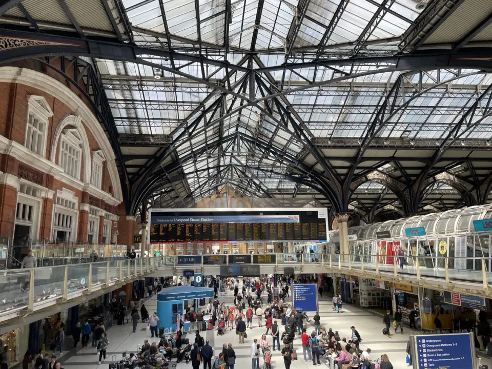 The concourse of Liverpool Street station under its glass roof, hundreds of passengers below