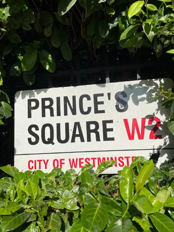 Уличная табличка Prince's Square W2, City of Westminster на фоне зелени