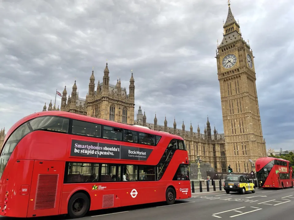 A red bus by the Palace of Westminster and Big Ben