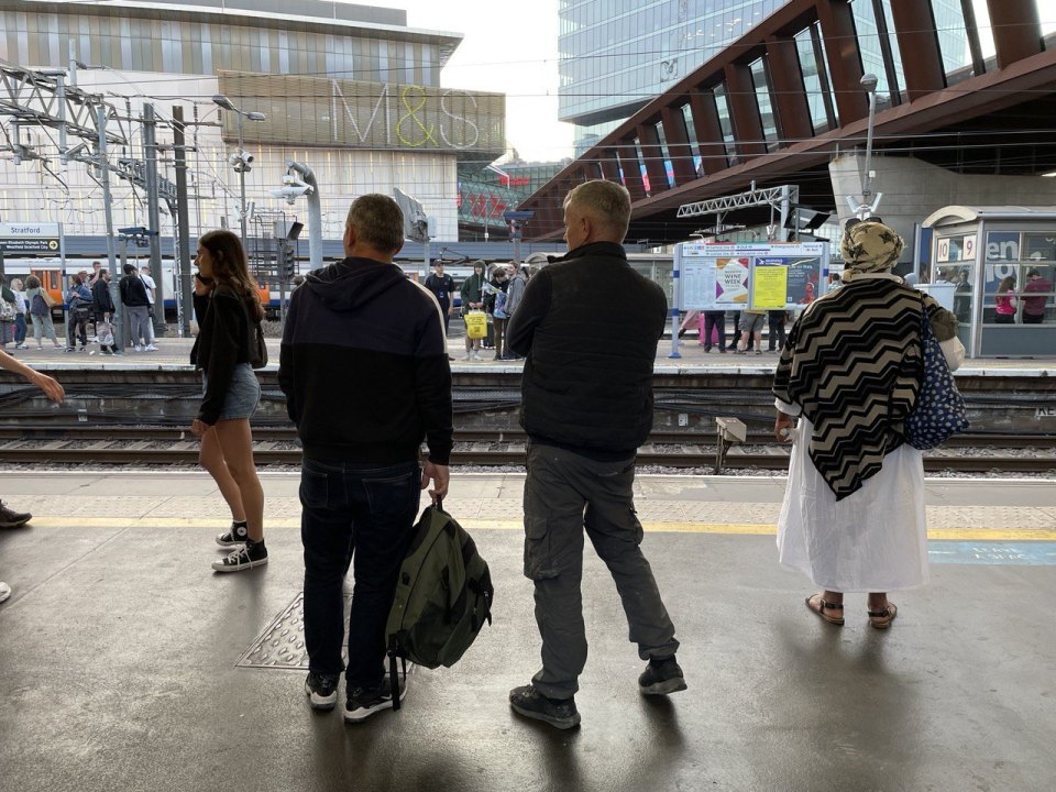 Passengers waiting for a train on a London station platform