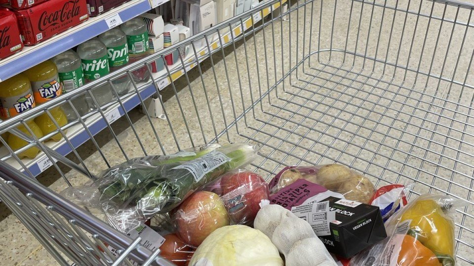 Тележка с продуктами у полок британского супермаркета