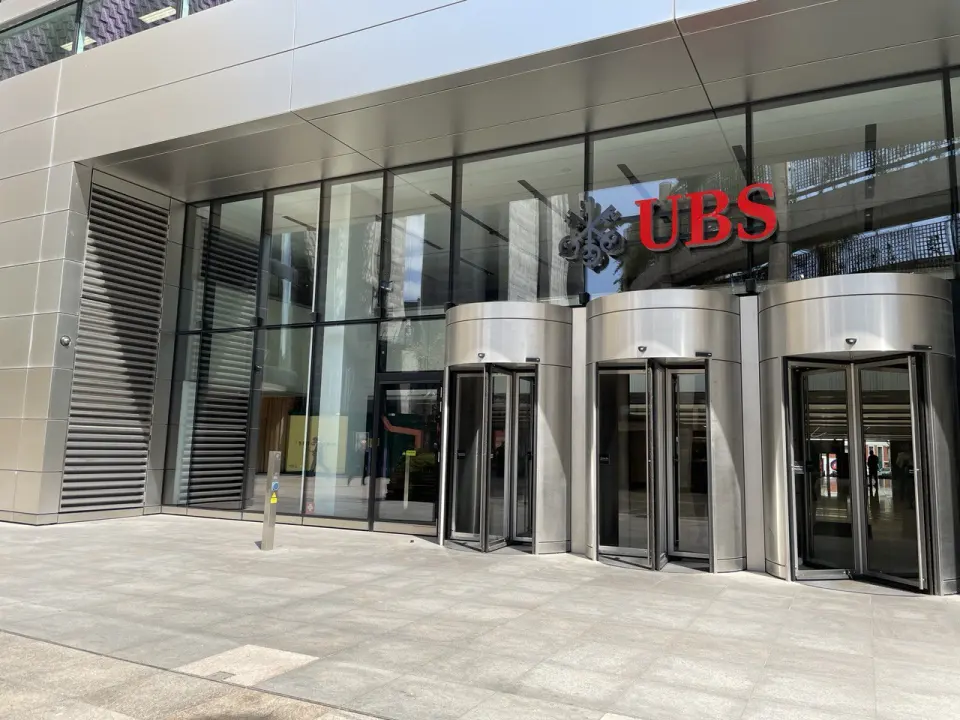 The glass entrance to the UBS office building in London with revolving doors
