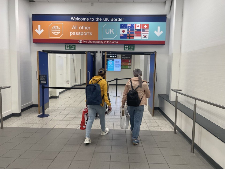 A 'Welcome to the UK Border' sign splitting arrivals into UK and All other passports lanes