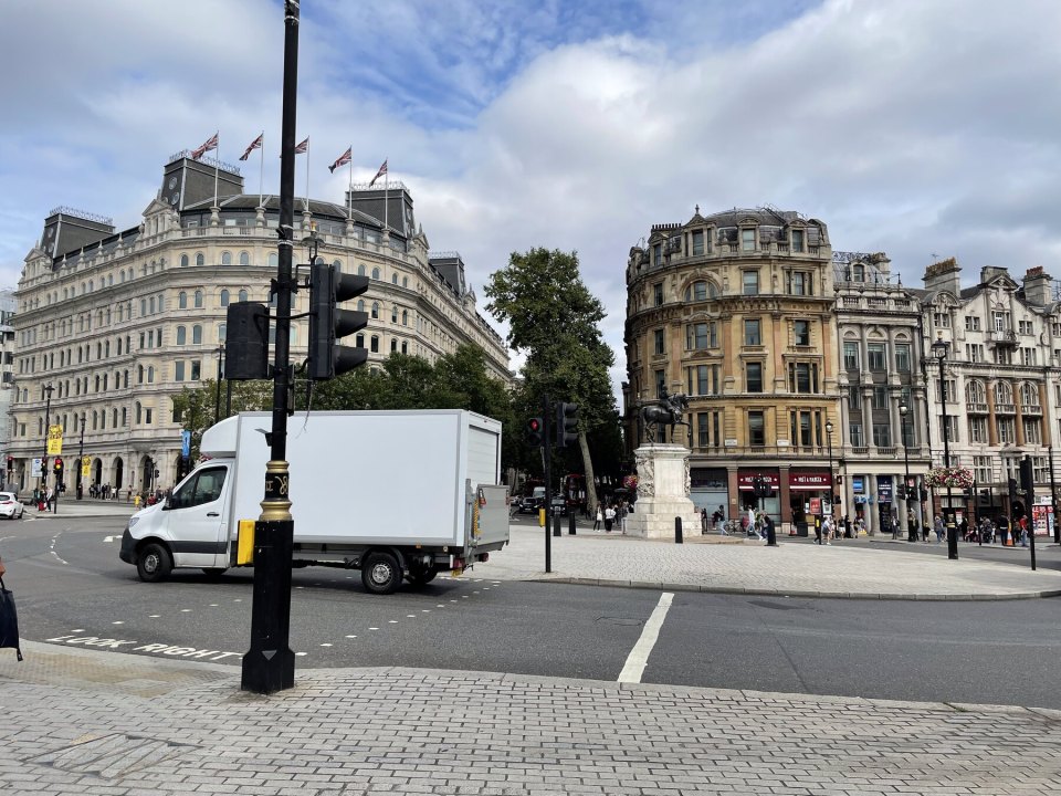 A white van at a London junction beside Victorian buildings