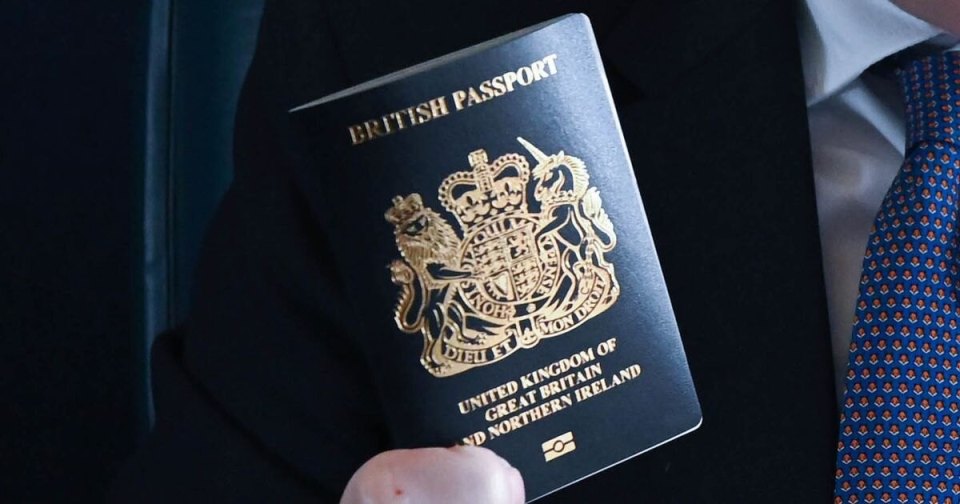 A British passport held by a man in a suit