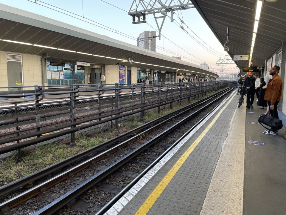 Platform of a British railway station with tracks and overhead lines