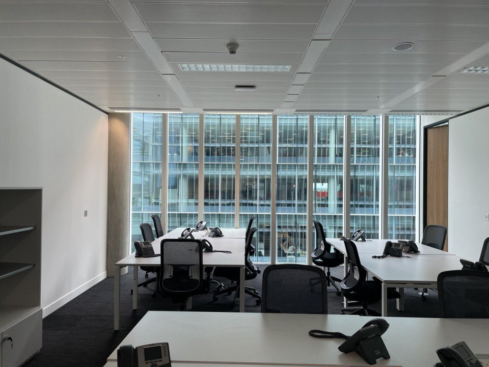 Bright office room with rows of desks and chairs