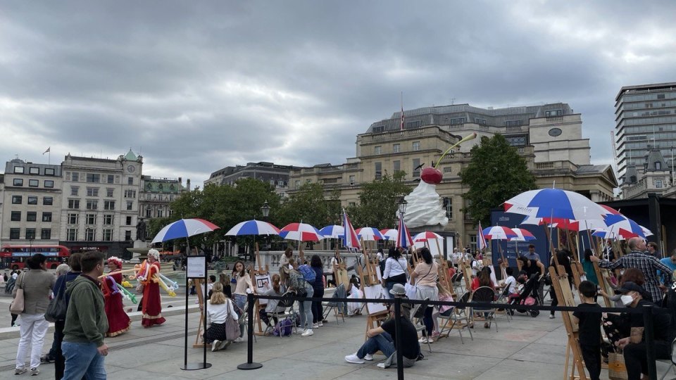 Heavy clouds and umbrellas in Trafalgar Square