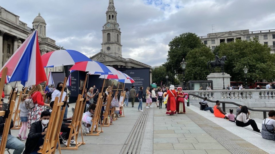 Umbrellas beneath a cloudy sky in Trafalgar Square