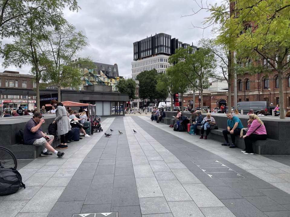 People in Britain in a city square beside St Pancras station in London