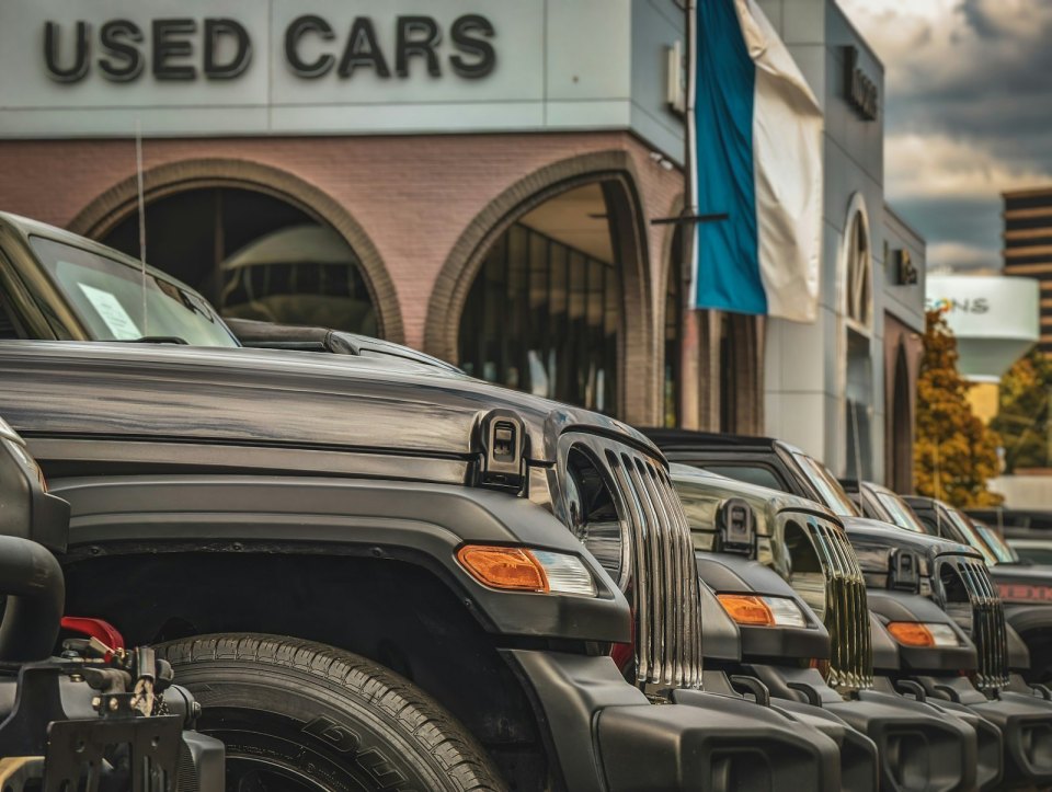 Ряд подержанных машин у автосалона «USED CARS»