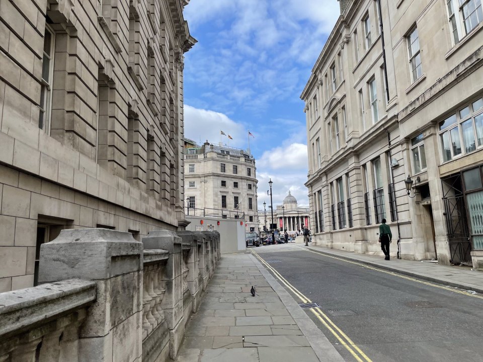 A street of government buildings in London with the National Gallery in the distance