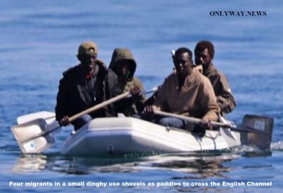 Four migrants in a small dinghy use shovels as paddles to cross the English Channel