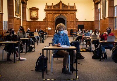 Студенты в масках сидят в социально дистанцированном классе в Оксфордском университете, где наблюдается рост инфекций.